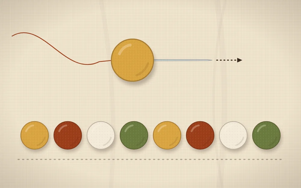 A needle and thread passing through a felt ball with a row of balls laid out in a repeating color order