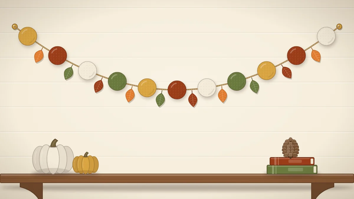 A garland of round felt balls in mustard, rust, cream and olive alternating with small felt leaves, hanging in a curve