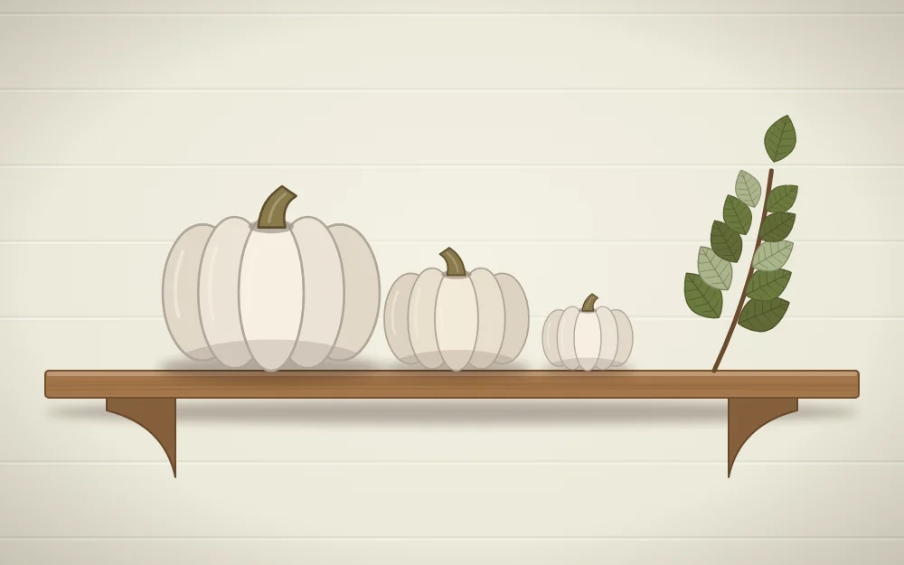 A minimal shelf with only three white pumpkins of different sizes and one sprig of leaves
