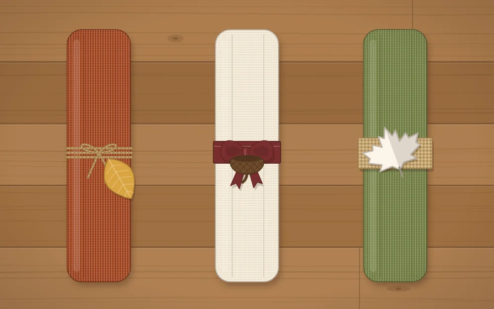 Three napkin ties in a row: twine with a felt leaf, ribbon with an acorn cap and burlap with a paper leaf