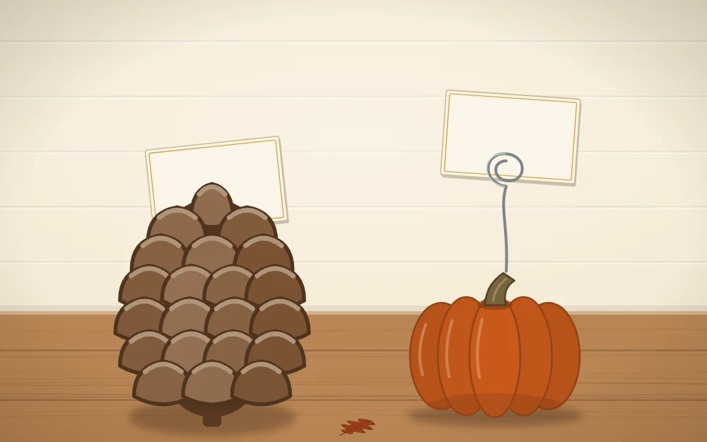 A pinecone holding a blank card between its scales beside a mini pumpkin with a wire coil card holder