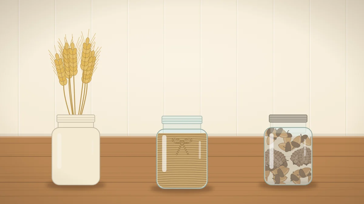 Three glass jars in a row: one painted cream holding wheat stems, one wrapped in twine and one filled with layers of acorns and small pinecones