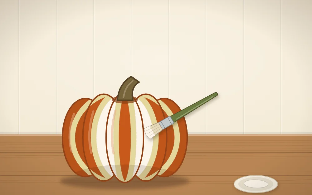 A pumpkin with tape strips running top to bottom and a flat brush painting between them