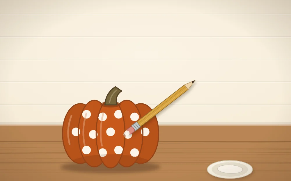 A small pumpkin being stamped with round dots from a pencil eraser, a paint dish beside it