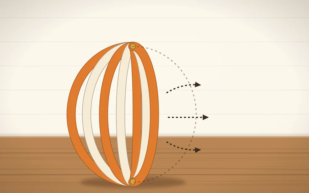A half-formed paper strip pumpkin with the strips being spread out evenly into a ball shape