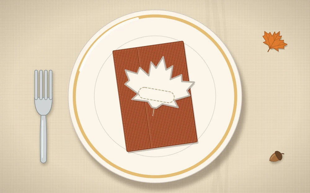 A paper leaf place card with a blank name area resting on a folded rust napkin on a plate