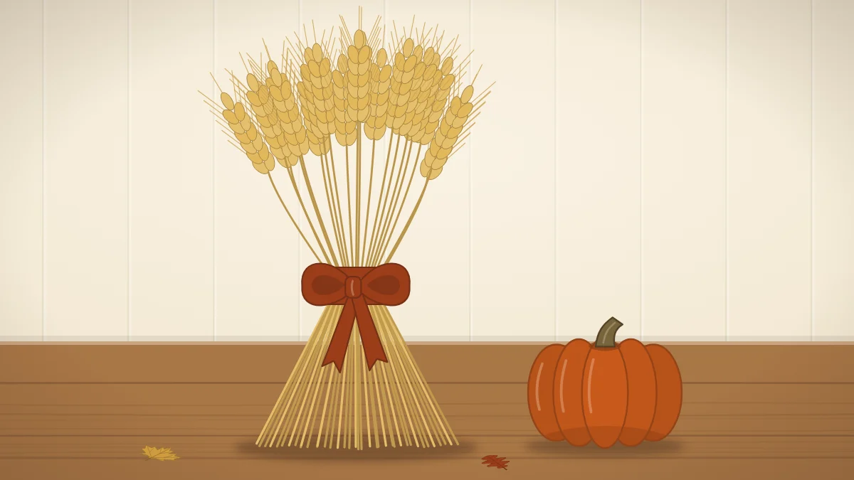 A standing sheaf of golden wheat tied with a wide rust ribbon on a wooden surface, with a small pumpkin beside it